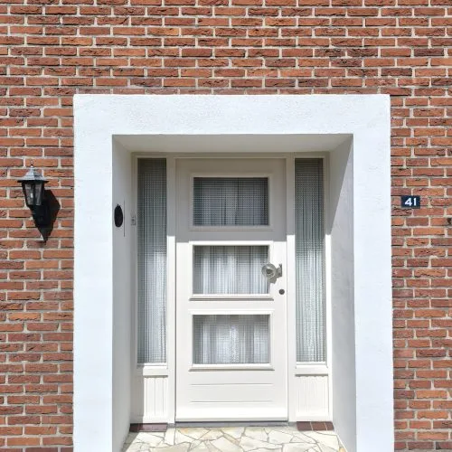 Klassieke voordeur met zijlichten en witgestucte omlijsting